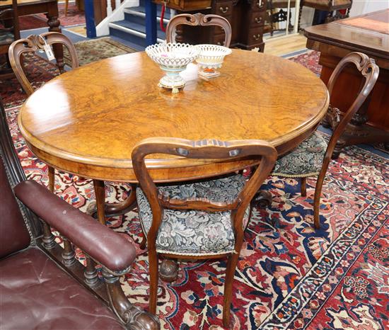 A Victorian oval figured walnut loo table together with a set of four Victorian mahogany balloon back dining chairs Table 142cm